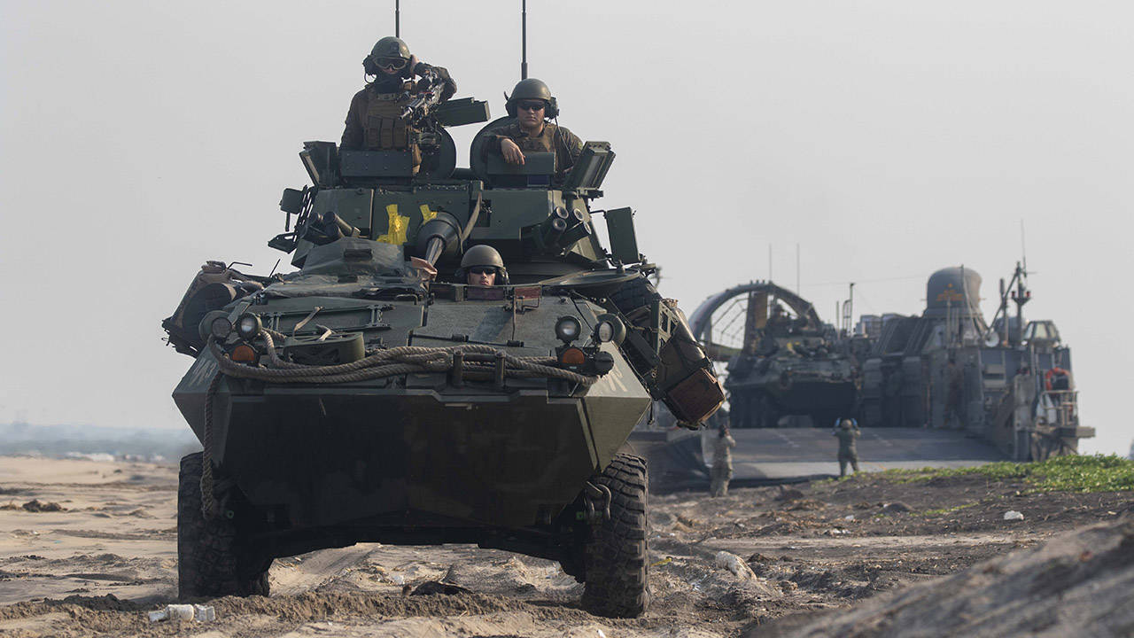 US Marines traverse the beach in a Light Armored Vehicle