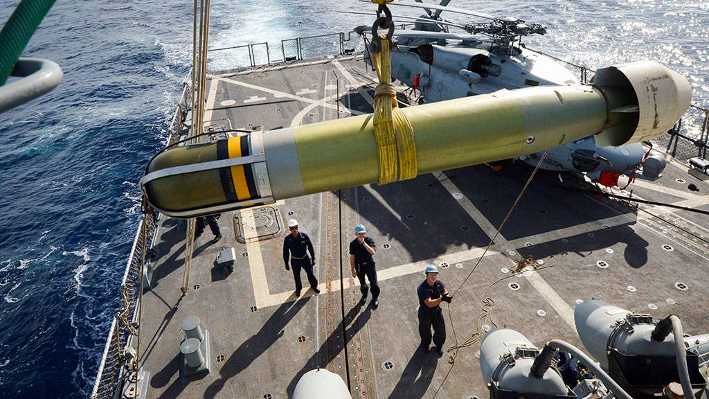 Sailors aboard the USS Winston S Churchill maneuver a Mark-54 torpedo to the flight deck